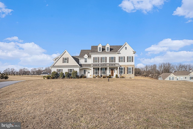 shingle-style home with a porch and a front lawn