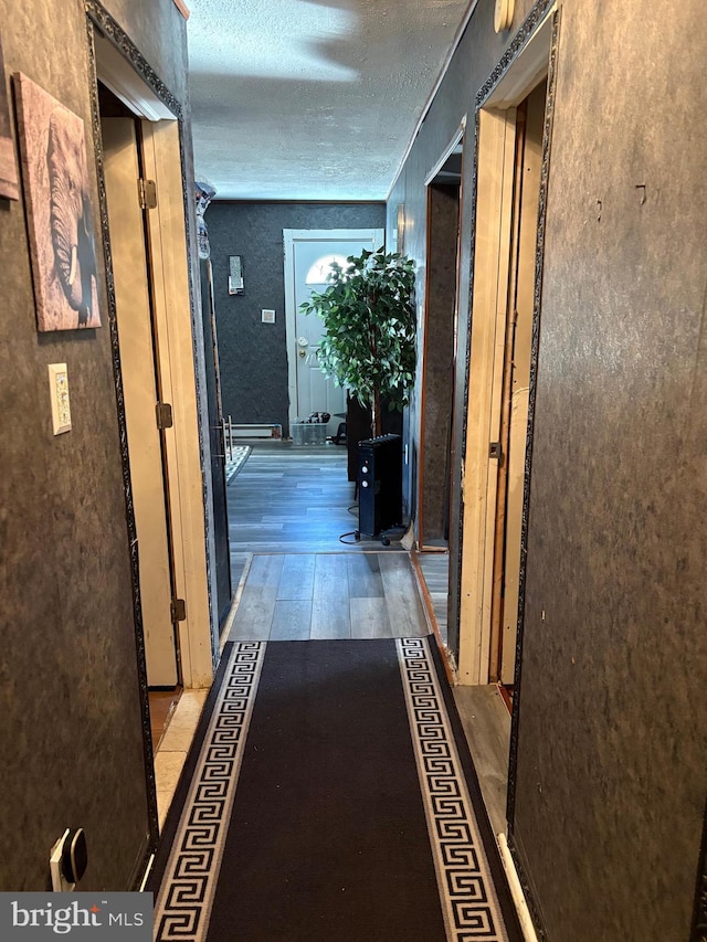 hallway featuring a textured ceiling and light wood-type flooring