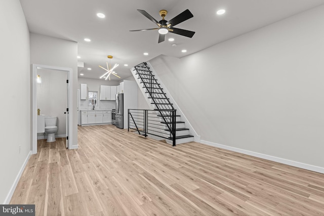 unfurnished living room with ceiling fan and light hardwood / wood-style floors