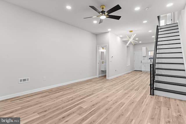 unfurnished living room featuring ceiling fan and light wood-type flooring