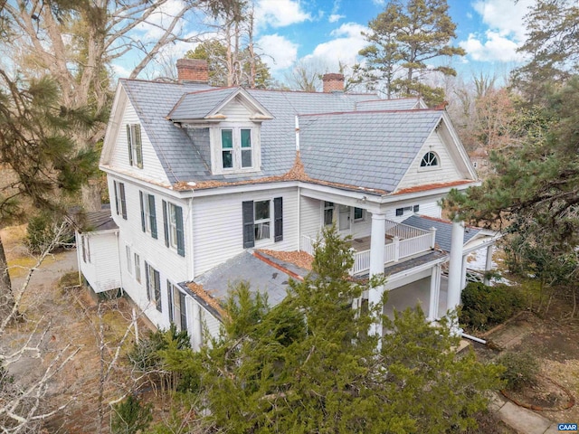 exterior space featuring a chimney and a balcony