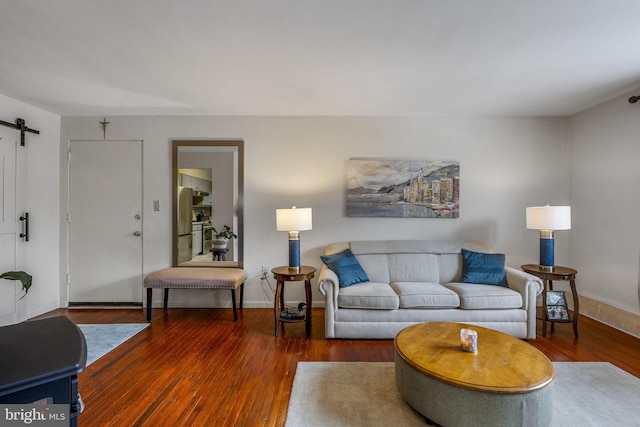 living room featuring dark hardwood / wood-style flooring and a barn door