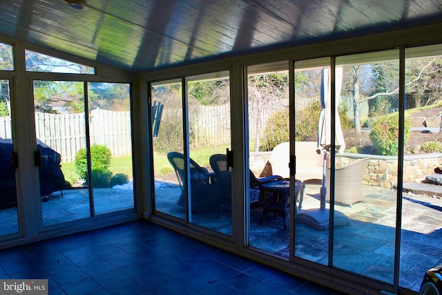 unfurnished sunroom with wooden ceiling, a wealth of natural light, and lofted ceiling