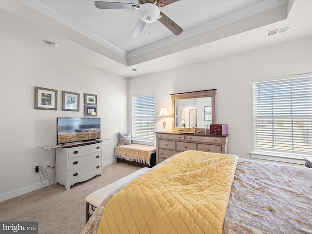 carpeted bedroom with crown molding, ceiling fan, and a tray ceiling