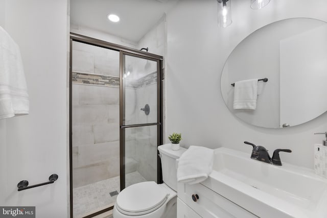 full bathroom with vanity, a shower stall, and toilet