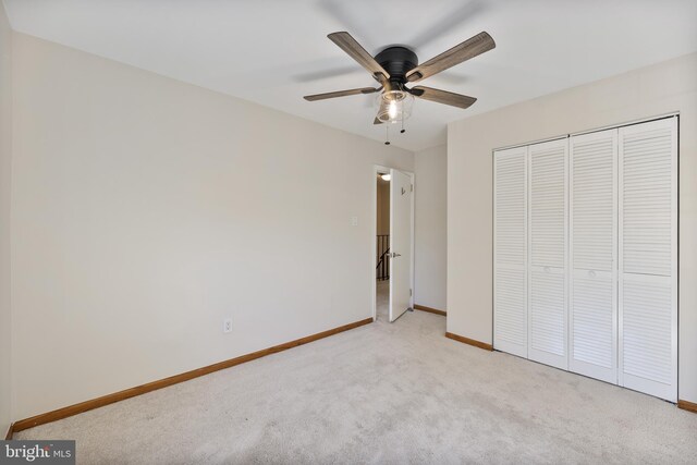 unfurnished bedroom featuring a closet, a ceiling fan, baseboards, and carpet floors