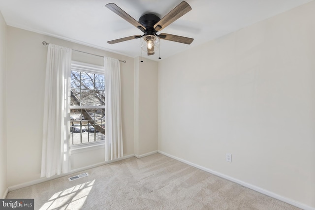 carpeted spare room featuring a ceiling fan, baseboards, and visible vents