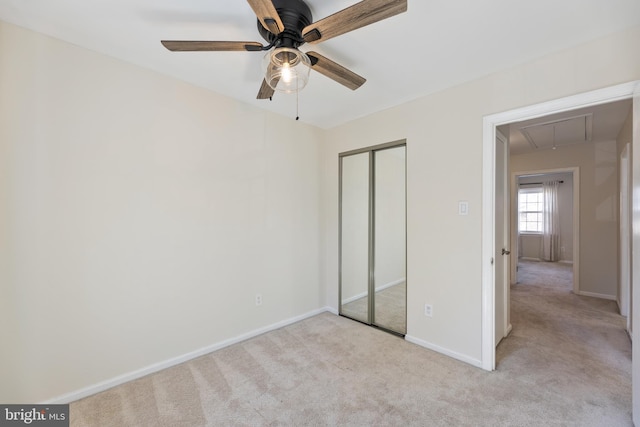 unfurnished bedroom with attic access, baseboards, a closet, and carpet floors