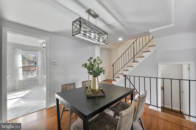 dining area with stairway, baseboards, and wood-type flooring