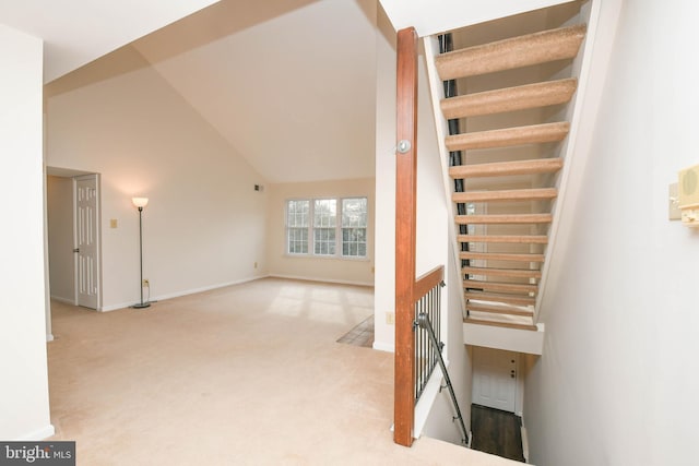 stairway featuring carpet and high vaulted ceiling