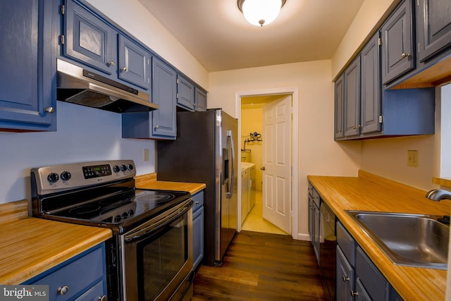 kitchen featuring blue cabinetry, stainless steel appliances, dark wood-type flooring, washer and clothes dryer, and sink