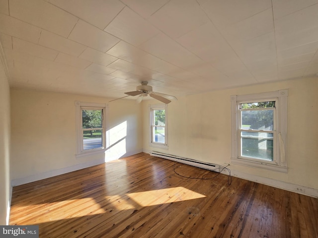 spare room featuring a baseboard heating unit and wood-type flooring