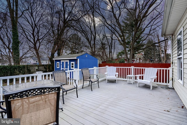 deck featuring fence private yard, outdoor dining area, and an outdoor structure