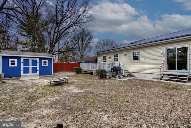 view of yard with entry steps, a deck, an outbuilding, and fence