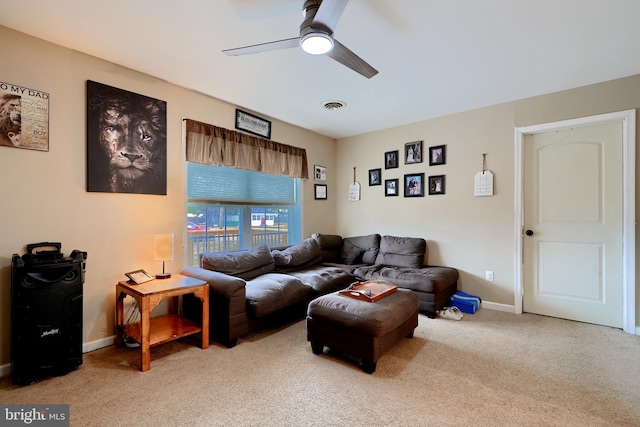 living area with a ceiling fan, light colored carpet, visible vents, and baseboards