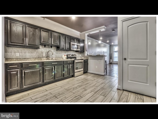 kitchen with sink, pendant lighting, crown molding, stainless steel appliances, and tasteful backsplash