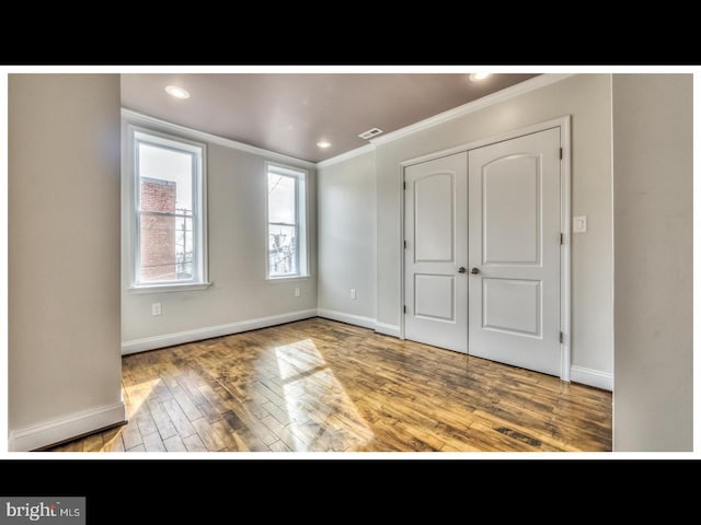 unfurnished room with crown molding and wood-type flooring