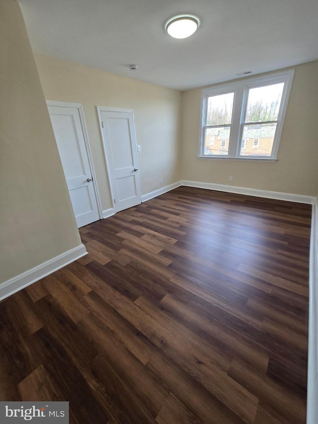 unfurnished room featuring dark wood-type flooring