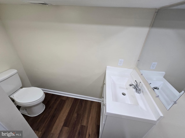 bathroom featuring vanity, wood-type flooring, and toilet