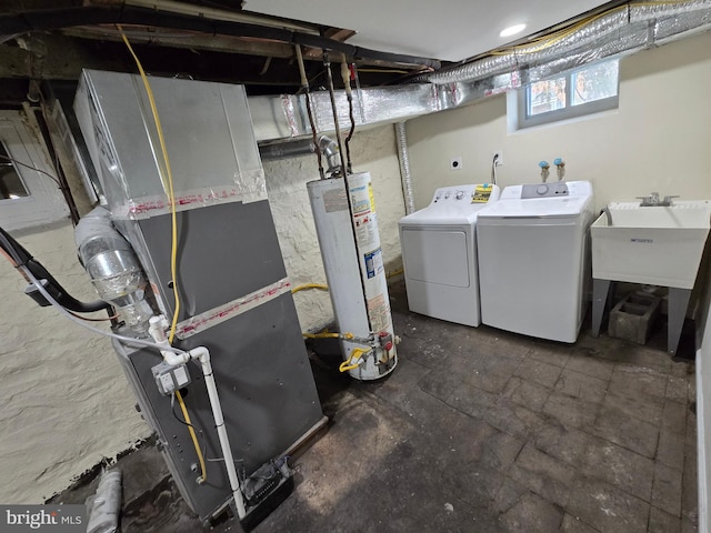 basement featuring gas water heater, sink, heating unit, and independent washer and dryer