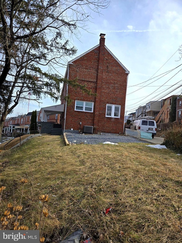 exterior space featuring cooling unit and a lawn