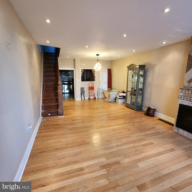 unfurnished living room featuring recessed lighting, a fireplace, and light wood-style flooring