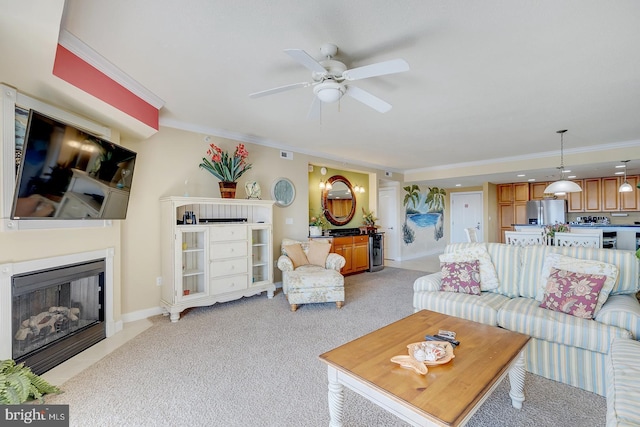 living room with a fireplace with flush hearth, ornamental molding, light carpet, ceiling fan, and baseboards