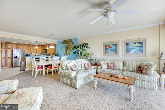 living area with light carpet, a ceiling fan, ornamental molding, and a textured ceiling