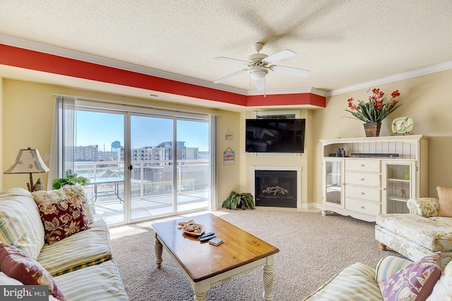 living room featuring ornamental molding, a glass covered fireplace, carpet flooring, and a textured ceiling