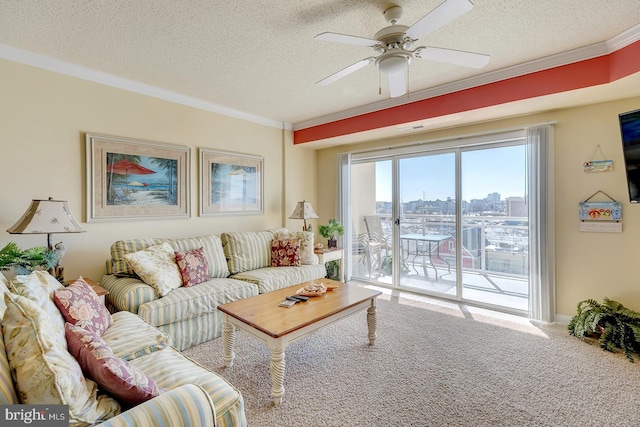 living room featuring a textured ceiling, carpet, a ceiling fan, and crown molding