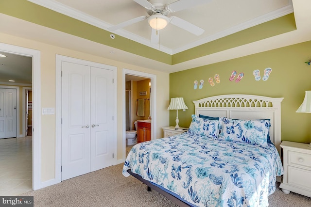 bedroom featuring ornamental molding, a tray ceiling, and a closet