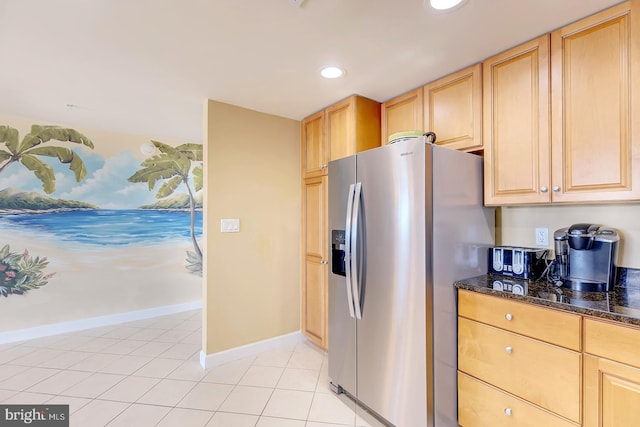 kitchen featuring recessed lighting, light brown cabinetry, light tile patterned flooring, dark stone counters, and stainless steel fridge with ice dispenser