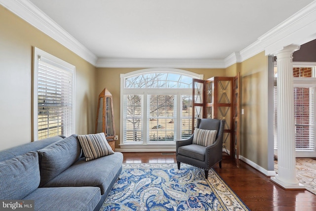 sitting room featuring baseboards, ornamental molding, dark wood finished floors, and ornate columns