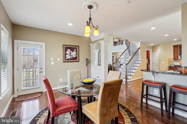 dining space featuring visible vents, stairway, dark wood-type flooring, ornate columns, and recessed lighting