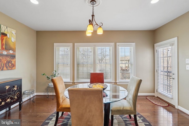 dining space with baseboards, a wealth of natural light, and wood finished floors