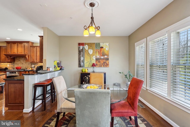 dining area with dark wood finished floors, a notable chandelier, recessed lighting, visible vents, and baseboards