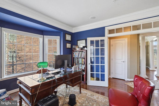 office area with crown molding, wood finished floors, decorative columns, and baseboards