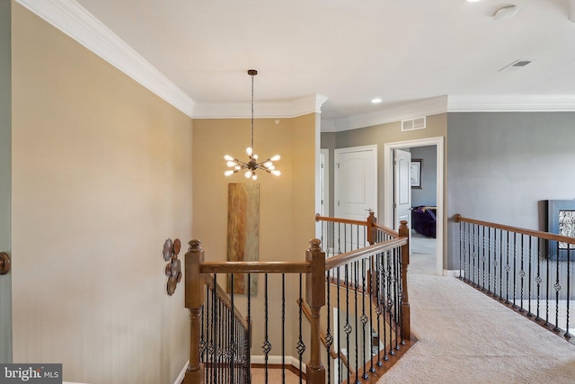 hall featuring visible vents, ornamental molding, an inviting chandelier, an upstairs landing, and carpet floors