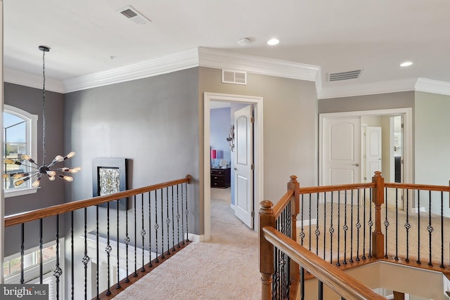 hall with visible vents, carpet flooring, and an upstairs landing