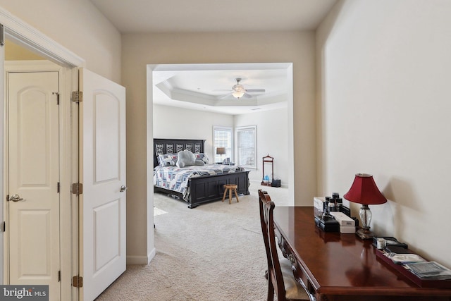 bedroom featuring a tray ceiling and light colored carpet