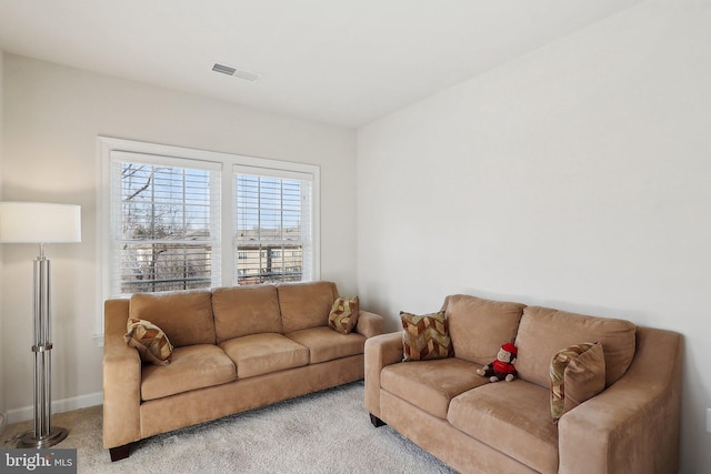 living room featuring light colored carpet, visible vents, and baseboards