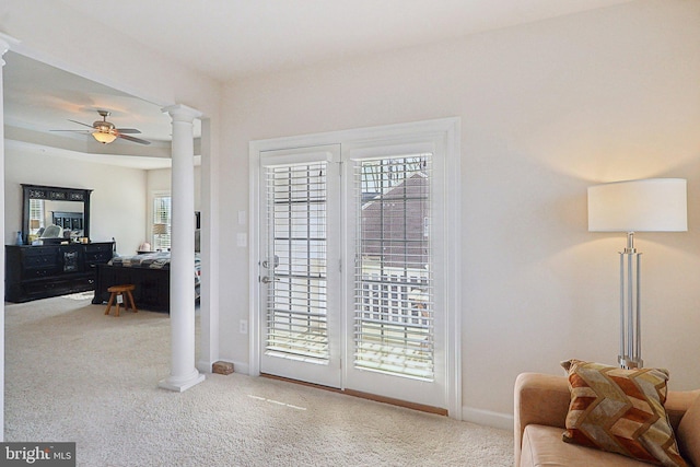 doorway to outside featuring ornate columns, baseboards, a ceiling fan, and carpet flooring