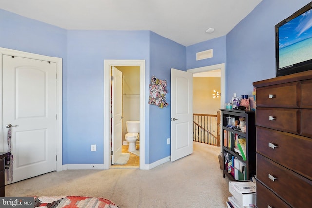 carpeted bedroom with ensuite bath, visible vents, and baseboards