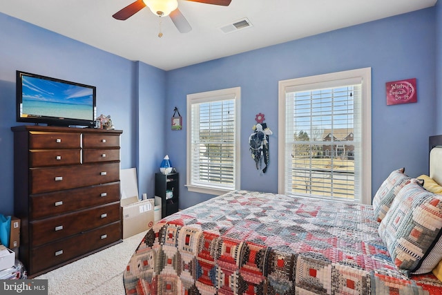 carpeted bedroom with visible vents and a ceiling fan