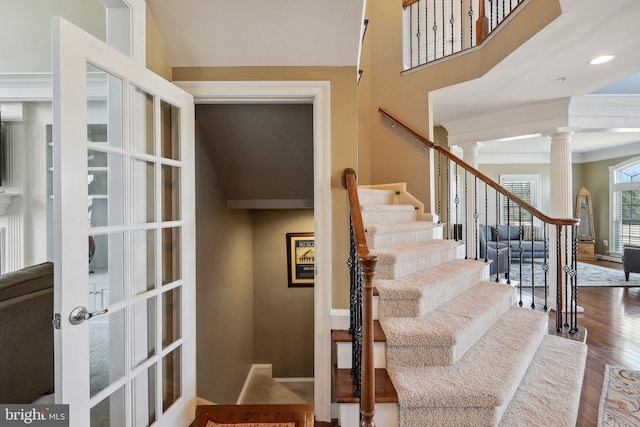 stairs featuring crown molding, recessed lighting, ornate columns, wood finished floors, and baseboards