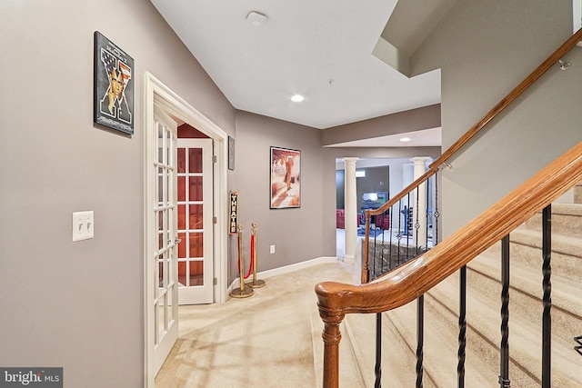 hallway with carpet, french doors, decorative columns, stairway, and baseboards