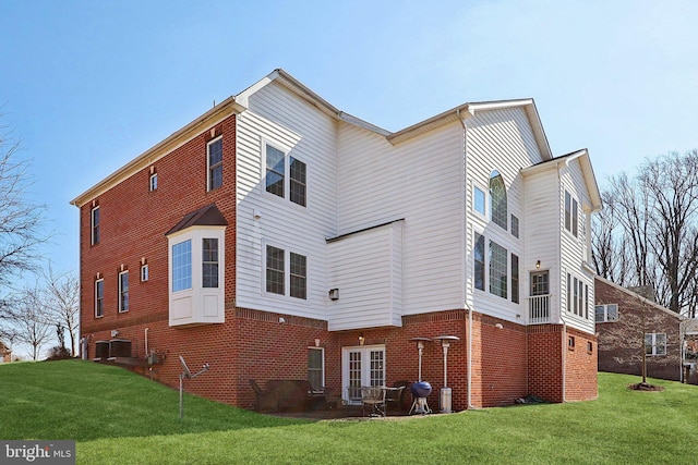 view of property exterior with central AC, brick siding, and a lawn