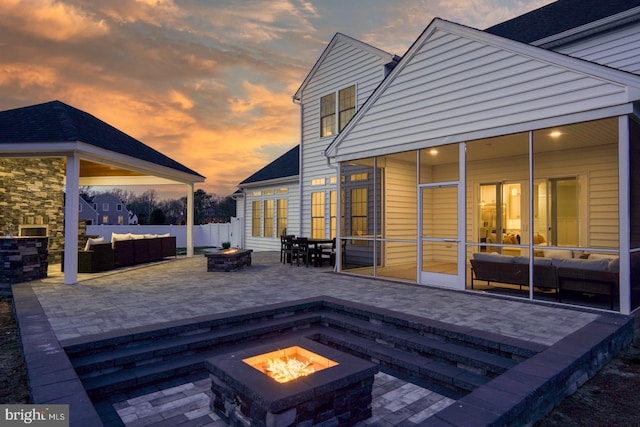 deck at dusk with an outdoor living space with a fire pit and a patio area