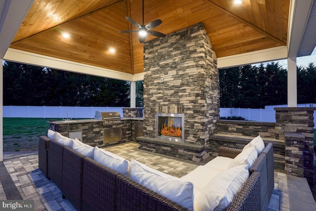 view of patio / terrace featuring grilling area, area for grilling, ceiling fan, and an outdoor stone fireplace