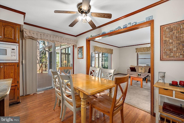 10133 Queens Cir, Ocean City, MD 21842 - dining space with crown molding, light wood-style floors, ceiling fan, and a wealth of natural light